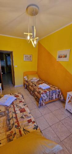 a room with two beds and a yellow wall at Casa Lory in Pescina