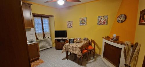 a dining room with a table and a television in a room at Casa Lory in Pescina