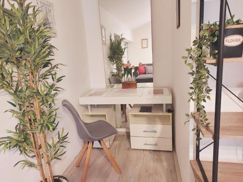 a desk and chair in a room with plants at Red Clay Apartments City Club in Belgrade