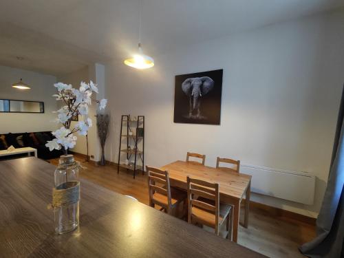 une salle à manger avec une table et une photo d'éléphant sur le mur dans l'établissement Appartement intra muros, à Avignon