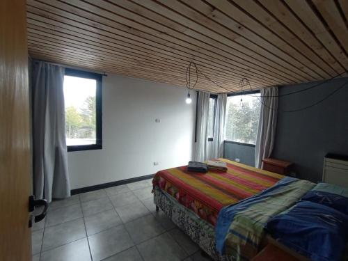 Un dormitorio con una cama con techo de madera. en Los soles de montaña, en Villa Pehuenia