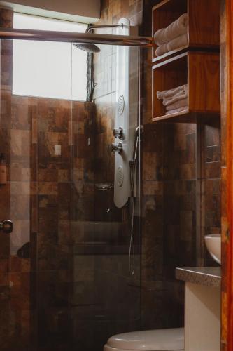 a bathroom with a shower with a toilet and a sink at Hacienda del Valle Sagrado in Urubamba