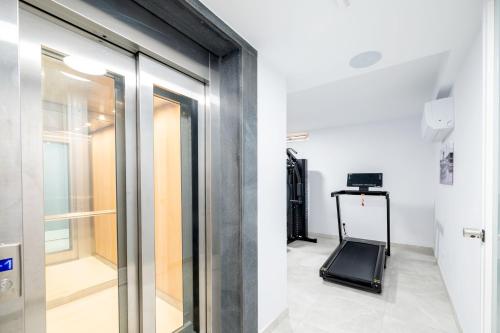 a room with a glass door and a treadmill at C4 Retreats by Georges Boutique Living in Xagħra
