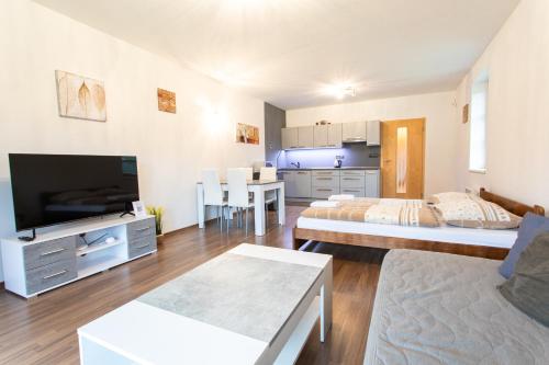 a living room with two beds and a kitchen at Apartmány pod Zakletým - Hotel Říčky in Říčky