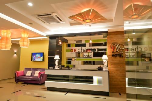 a lobby of a hotel with a couch and a tv at De Champs Hotel in Kuantan