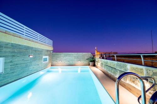 a swimming pool on the roof of a building at C4 Retreats Gozo in Xagħra