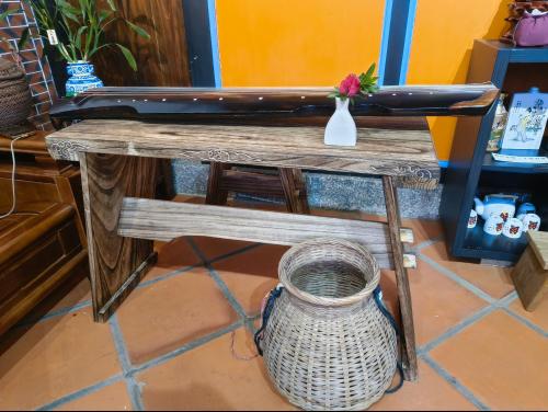 a wooden bench with a wicker basket under it at 湖峰古厝民宿 in Jinning