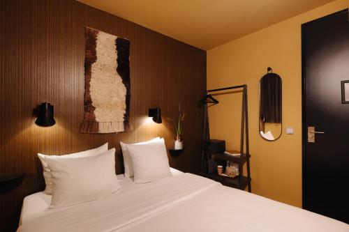 a bedroom with a large white bed with white pillows at Hotel V Frederiksplein in Amsterdam