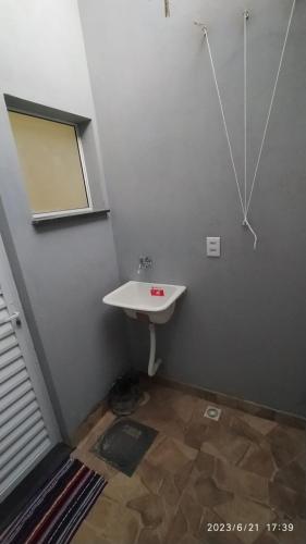 a small bathroom with a sink and a mirror at Orlando Braz Mini Apart in Bauru