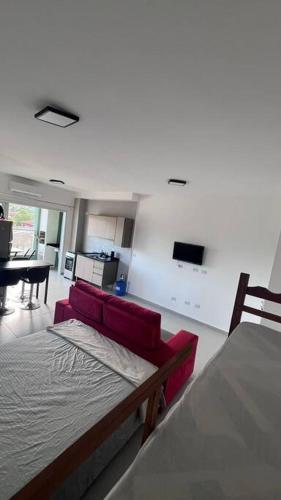 uma sala de estar com um sofá vermelho e uma mesa em Studio para locação Pereque-Açu em Ubatuba