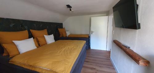 een slaapkamer met een bed met een honkbalknuppel aan de muur bij Cottage MaarBurg in Ulmen