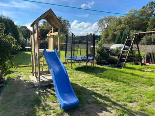 a playground with a blue slide in the grass at Ferienwohnung Winzenburg Natur nah und ruhig gelegene Ferienwohnung nah am Steinhuder Meer und Dinopark Münchehagen in Rehburg-Loccum