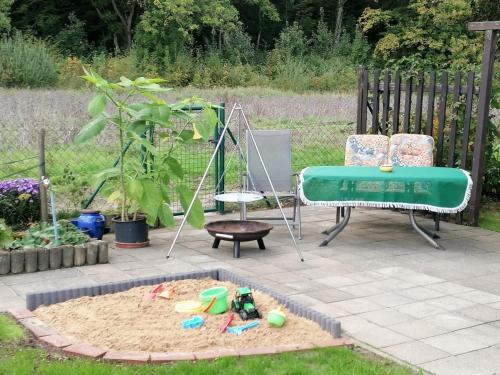 a garden with a sandbox and a swing and a table at Ferienwohnung Winzenburg Natur nah und ruhig gelegene Ferienwohnung nah am Steinhuder Meer und Dinopark Münchehagen in Rehburg-Loccum