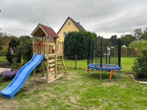 a playground with a slide and a playset at Ferienwohnung Winzenburg Natur nah und ruhig gelegene Ferienwohnung nah am Steinhuder Meer und Dinopark Münchehagen in Rehburg-Loccum