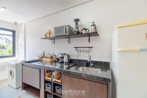 a kitchen with a sink and a refrigerator at Studio Charmoso apenas 200m da Praia - PMO0404 in Florianópolis