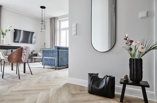 a living room with a blue couch and a vase with flowers at Villa Esperance - Suite Céleste mit Balkon, Dampfbad Whg 10 in Binz