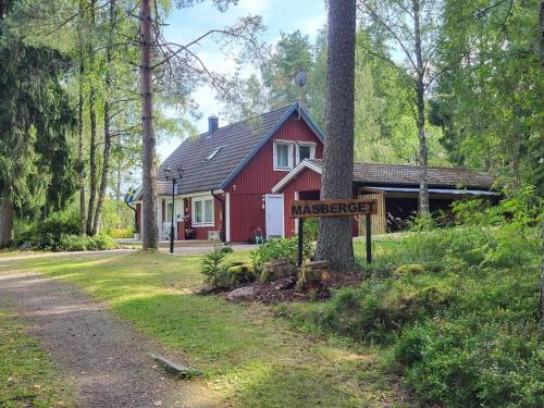 a red house with a sign in front of it at Landhaus Måsberget in Kristinehamn