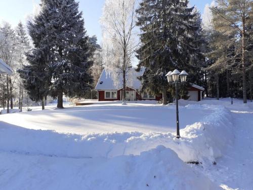a snow covered yard with a light pole in front of a house at Landhaus Måsberget in Kristinehamn