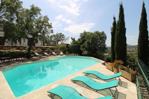 une piscine avec des chaises longues et un complexe hôtelier dans l'établissement Villa Dolce pour 8 personnes avec piscine privée à La Londe-Les-Maures, à La Londe-les-Maures