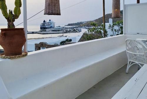 a white balcony with a view of the ocean at Mykonos Seaview Nests - Tourlos Getaways in Tourlos