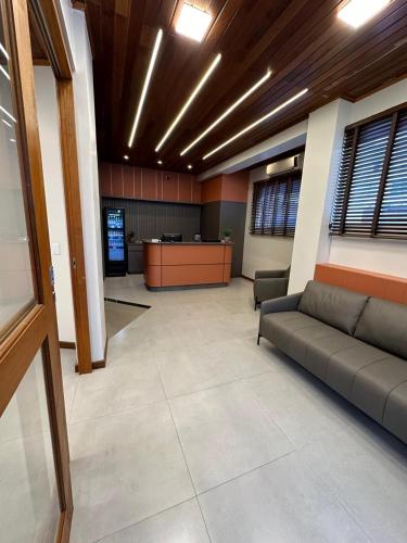 an office with a couch in the middle of a room at Rio Jordao Hotel in Siderópolis