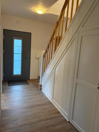 an empty hallway with a door and a stairway at Haus Bootsmann Süd in Wüstenei Mooräcker