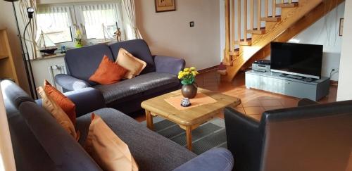 a living room with a couch and a table at Küstenglück Nessmersiel in Neßmersiel