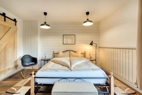 a bedroom with a bed and a chair at Sweet Home Apartments in Tösens