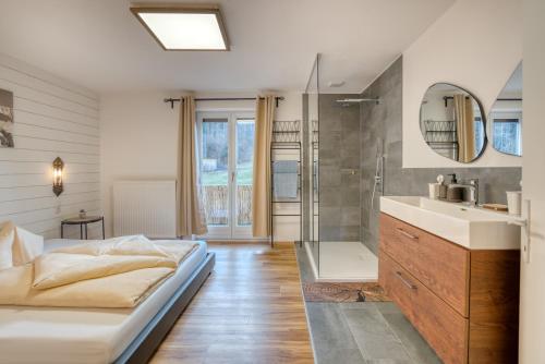 a bathroom with a bed and a sink and a shower at Sweet Home Apartments in Tösens