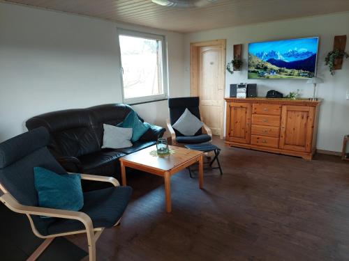 un salon avec un canapé, des chaises et une table dans l'établissement Ferienhaus Landlust - b69076, à Meschede
