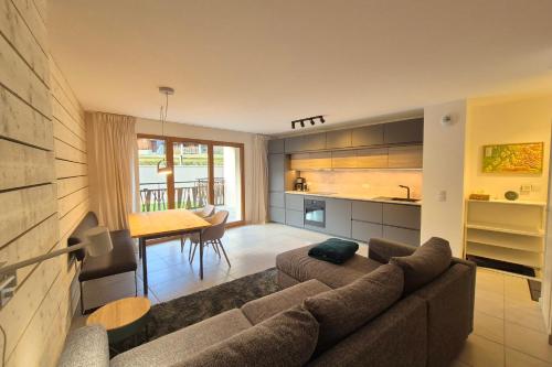 una sala de estar con un sofá y una mesa en Découvrez ce magnifique appartement au pied des pistes à La Féclaz, en La Féclaz
