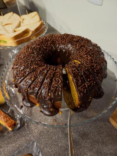 a chocolate cake on a glass plate on a table at Rio Jordao Hotel in Siderópolis