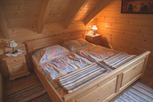ein Schlafzimmer mit einem Bett in einer Blockhütte in der Unterkunft Ferienhaus Klippitzblick in Klippitztorl