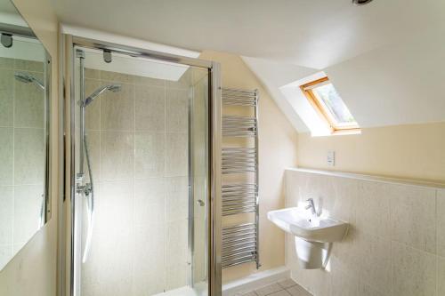 a bathroom with a shower and a sink at Stanton, woodland lodge with hot tub for 14 in Oakamoor