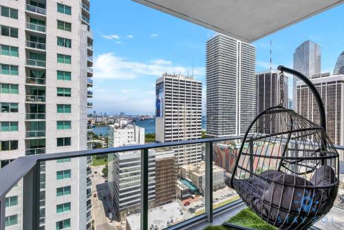 a swing on a balcony with a view of a city at Beautiful Apartment with gym and amazing Pool in Miami