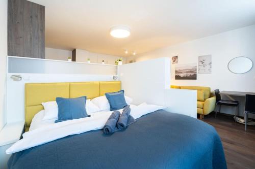 a bedroom with a large bed with blue pillows at Elegant Studio in the Heart of Brno in Brno