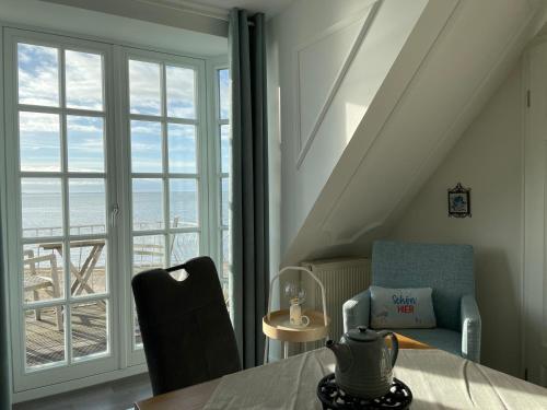 a room with a table and chairs and a window at Huus Lüttenblick Whg Strandblick in Wyk auf Föhr
