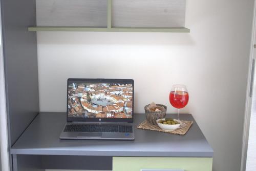 a laptop on a table with a glass of wine at Locazione Turistica Rania in Lucca