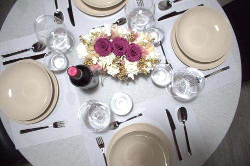 a white table with white plates and purple flowers on it at Locazione Turistica Rania in Lucca