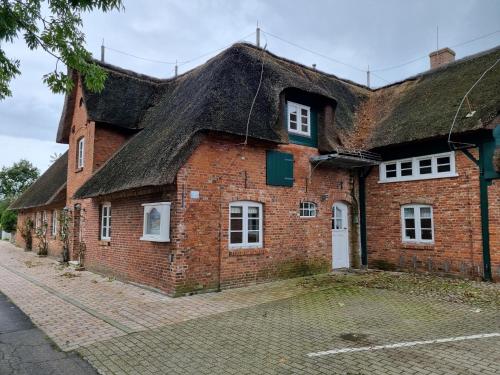 an old brick building with a thatched roof at Reetglück in Wrixum