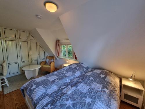 a bedroom with a bed with a blue comforter at Friesentraum in Alkersum