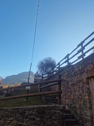 a stone retaining wall with a wooden fence at Chalet Casargo in Casargo