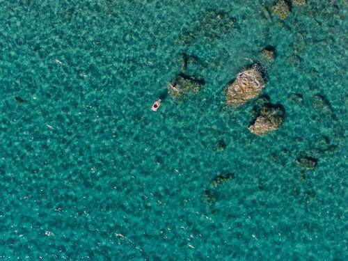 an aerial view of some rocks in the water at VK Villas - Votsalo & Kyma Villas, By ThinkVilla in Léntas