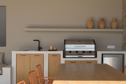 a kitchen with a wooden table and a stove at VK Villas - Votsalo & Kyma Villas, By ThinkVilla in Léntas