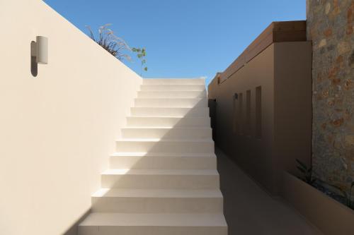 a set of stairs leading up to a building at VK Villas - Votsalo & Kyma Villas, By ThinkVilla in Léntas