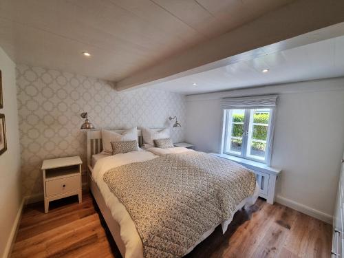 a bedroom with a large bed and a window at Hüs Lorenzen in Oevenum