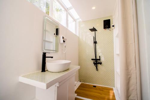 a white bathroom with a sink and a mirror at HayyaHayya Villas in Ocoy