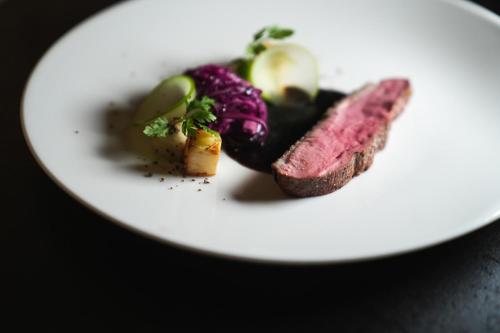 a plate of food with meat and vegetables on it at Hotel Alpenjuwel 4 Sterne Superior in Tux