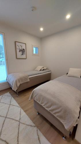 a bedroom with two beds and a window at Villa Tervas, Arctic circle in Rovaniemi