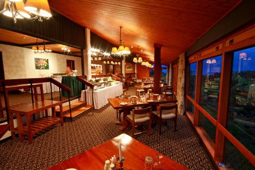 una sala da pranzo con tavoli e sedie in un ristorante di The Ark Lodge a Nyeri